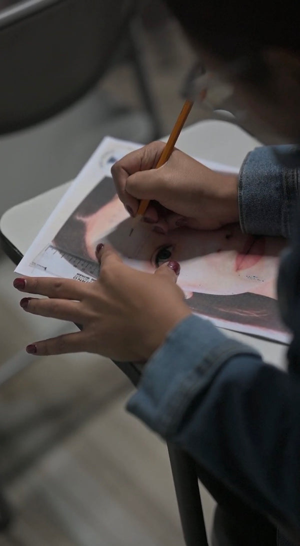 Microblading student practicing eyebrow design on paper during hands-on training 